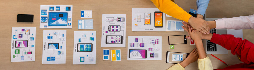 Wall Mural - top view banner of startup company ui or ux developer joining hand over user interface prototype for