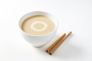 Canvas Print - Close-up of a Bowl of Creamy Soup with Cinnamon Sticks