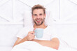 © be free - Weekend wakeup. Man relax with hot drink in bedroom. Man relax in bed with morning coffee. Breakfast in bed at cozy hotel room. Man with coffee in bed. Morning at home
