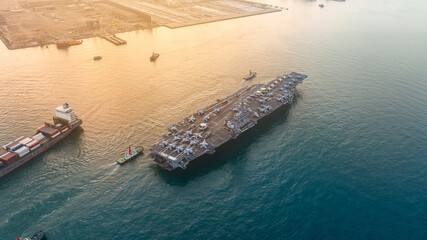 war ship Nuclear Navy ship at sunrise, Military navy carrier full loading fighter jet aircraft for prepare troops. nuclear carrier running in the ocean.