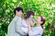 © maroke - 緑の中で子供を抱っこする家族