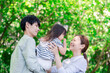 © maroke - 緑の中で子供を抱っこする家族
