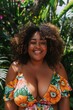 © senyumanmu - portrait of a smiling plus size woman with warm brown skin wearing a vibrant floral sundress