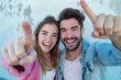 © Emanuel - Young couple or friends, a man and a woman in casual attire, pointing directly at the camera with enthusiastic and engaging expressions