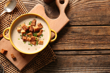 Wall Mural - Pot of tasty cream soup with croutons on wooden background