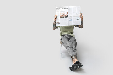 Canvas Print - Man with newspaper on grey background