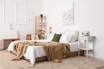 Poster - Interior of light bedroom with cozy bed and reed diffuser on bedside table