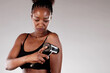 © Andrey Popov - Young African American woman using a massage gun machine