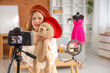 © Pixel-Shot - Teenage fashion blogger with toy bear recording video at home