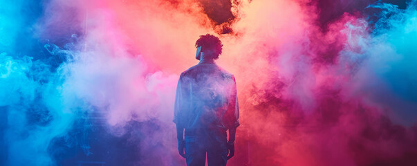 Artist rapper at a music concert on stage singing seen from the back with pink and blue smoke. Hip hop rap artist live performance.