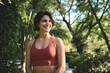 © insta_photos - Happy smiling fit sporty active slim confident young Hispanic woman wearing sportswear top enjoying summer sunny day looking away standing in green nature park or forest. Copy space.