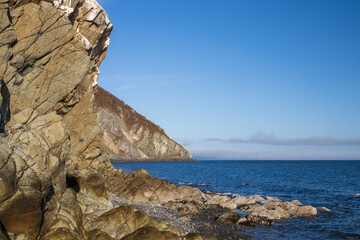 Beautiful seascape. View of the rocky sea coast and cape. Majestic cliff and rocks on the seashore. Journey to the sea. Coast of the Sea of Okhotsk, Magadan region, Russian Far East.