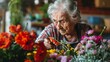 © Sasint - Elderly woman arranging a vibrant bouquet of flowers, engrossed in her floral hobby