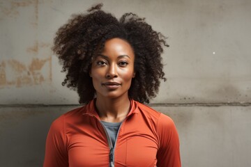 Wall Mural - Portrait of a content afro-american woman in her 40s sporting a technical climbing shirt isolated on light wood minimalistic setup