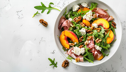 Summer salad bowl with sweet grilled peach, jamon, soft cheese, walnuts and fresh arugula on white kitchen table background, top view