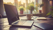 © khonkangrua - A laptop and coffee cup on a sunlit desk, surrounded by plants, creating a serene and productive home office environment.