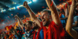 © khonkangrua - A group of ecstatic soccer fans celebrating a victory with raised arms, confetti, and a vibrant stadium atmosphere.