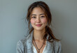 © Muhammad - photo of attractive Japanese woman her early mid twenty smiling standing upright against white background She wearing business casual attire long sleeve cardigan sweater over top of her shirt Her hair