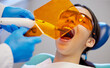 © Lumeez23/peopleimages.com - Filling, goggles and hands with woman at dentist for oral hygiene or dental care appointment closeup. Checkup, healthcare and medical visor with patient in chair at clinic for mouth cleaning or exam