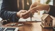 © Irina Ukrainets - Real estate agent handing over the house keys to a client in an office setting. Conceptual image symbolizing property ownership, real estate transactions, or investment. Professional stock photo. AI