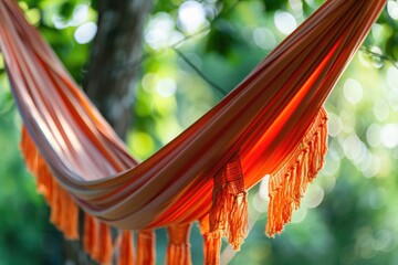 Canvas Print - A bright orange hammock hangs between two tree branches