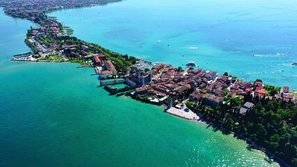 Wall Mural - Castello Scaligero di Sirmione Lake Garda Aerial View with Blue Water and Shoreline, Idyllic Summer Vacation Destination, Clear Sky and Historic Castle Background