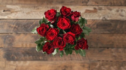 Wall Mural - A top down view of a stunning arrangement of vibrant red roses set against a backdrop of light wooden hues