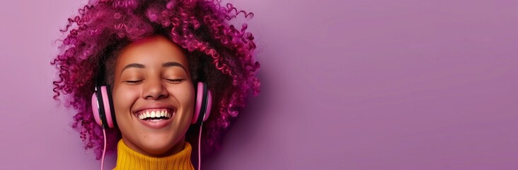 Wall Mural - a smiling Black woman with pink hair wearing headphones on a solid background, banner with space for copy