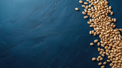 Pile of soybeans spills over dark blue textured surface