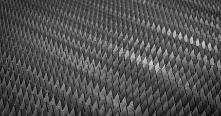 Poster - A close up of a metal surface with many small triangles. The image has a dark and industrial feel to it