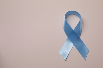 Wall Mural - International Psoriasis Day. Light blue ribbon as symbol of support on beige background, top view. Space for text