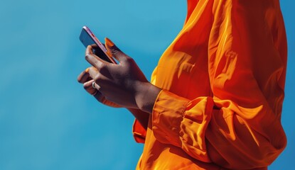 Wall Mural - A woman is holding a cell phone in her hand and appears to be texting