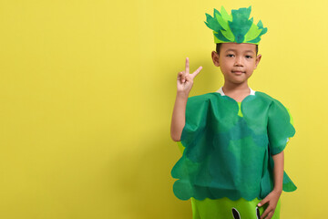 Cute child boy wearing vegetable costume isolated on yellow background