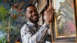 © ckybe - A cheerful African American man adorning a contemporary home with a photo frame and artwork.