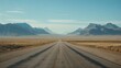 © InnovPixel - A straight, empty road leads through a vast desert landscape flanked by mountains under a clear blue sky.