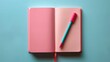 © Nuntapuk - Open pink notebook with a pink and blue pen on a blue background. Ideal for productivity, study, and creativity themes.