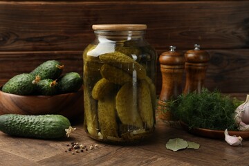 Wall Mural - Pickled cucumbers in jar, vegetables and spices on wooden table