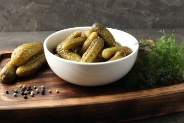 Wall Mural - Pickled cucumbers in bowl, dill and peppercorns on wooden board, closeup