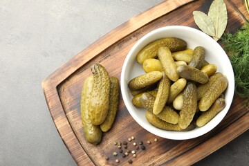Wall Mural - Pickled cucumbers in bowl, dill and peppercorns on grey textured table, top view