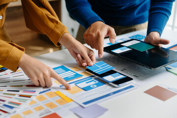 Wall Mural - close up view of ui developer team brainstorming on their project with laptop, smartphone and digita