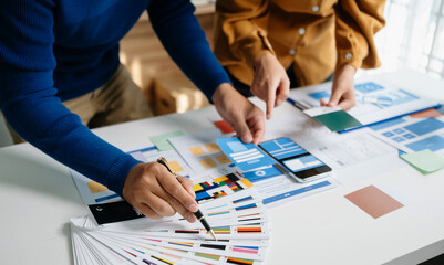 Wall Mural - close up view of ui developer team brainstorming on their project with laptop, smartphone and digita