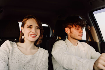 young couple in a car on a summer trip