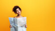 © Prostock-studio - African American young woman with curly hair appears confused and uncertain as she holds an unfolded map in her hands, looking up and to the side as if seeking guidance, copy space