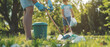 © DreamyStudio - Closeup of family picking up trash outdoors and eco volunteering in park, copy space