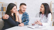 © Prostock-studio - A young couple sits at a doctors office, listening intently as the doctor explains something on a tablet. The woman is leaning into the mans arm, and he is looking at the tablet with a smile