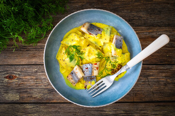 Wall Mural - Marinated herring fillets in mustard sauce with dill and lettuce on wooden table
