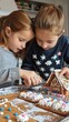 © vadosloginov - Two young girls are focused on decorating gingerbread houses. One girl is using frosting to decorate the roof of her house while the other one looks on. They are in a home setting and have a variety o