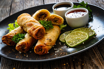 Poster - Spring rolls and sauces on wooden table
