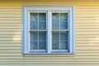 © Mamstock - Vinyl siding on house with window frames, close-up view.