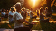 © OMD - A group of people practicing outdoor meditation or yoga in a park at sunset. They are sitting on mats with their hands in a prayer position.